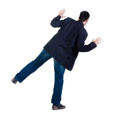 Balancing young man in jacket. Rear view. clipart