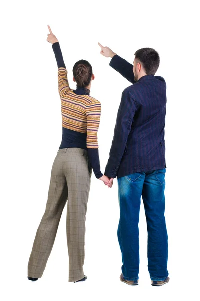 Young couple pointing at wall. Rear view. — Stock Photo, Image