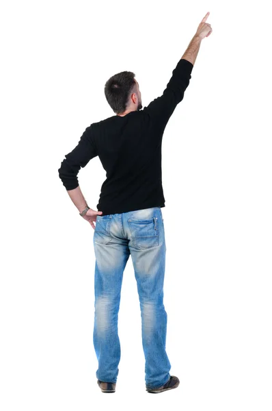 Young man pointing at wall. rear view. — Stock Photo, Image