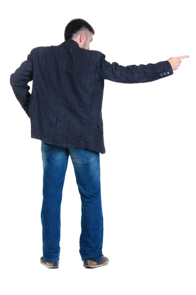 Young man pointing at wall. rear view. — Stock Photo, Image