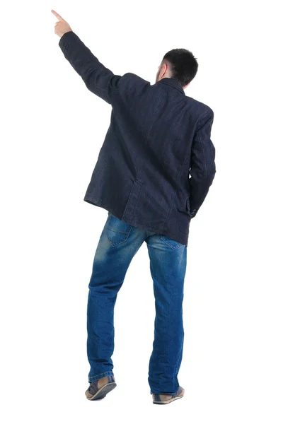 Young man pointing at wall. rear view. — Stock Photo, Image