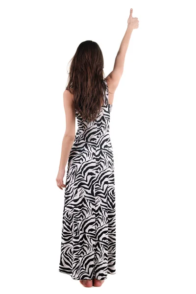 壁を指してドレスで美しい若い女性。背面ビュー. — ストック写真