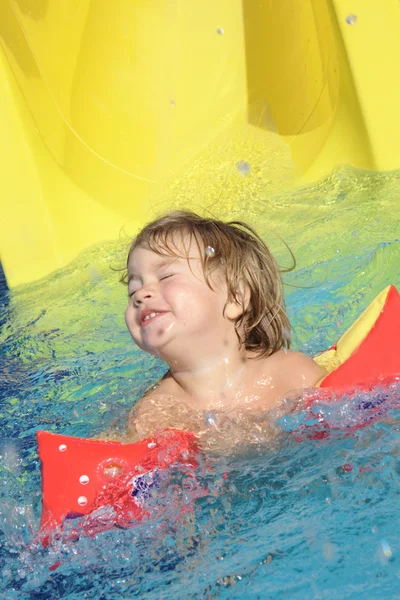 Ευτυχισμένο παιδί διασκεδάζοντας σε υδάτινο πάρκο Εικόνα Αρχείου