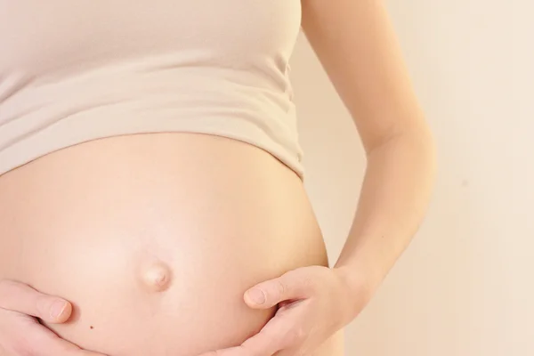 Terhes nő fogdossa a hasát Stock Kép