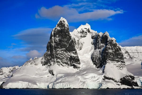 南極の青い空を背景の美しい雪をかぶった山々 ストック画像