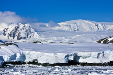 Beautiful snow-capped mountains against the blue sky in Antarctica clipart