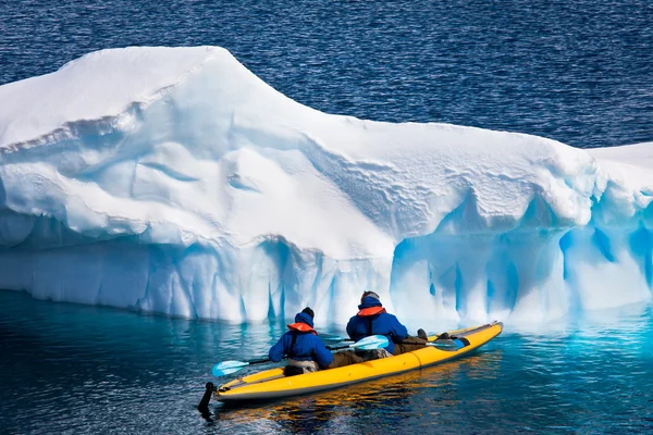 两个男人在一艘独木舟在南极冰山间 — 图库照片