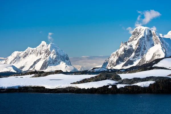 南極の青い空を背景の美しい雪をかぶった山々 — ストック写真