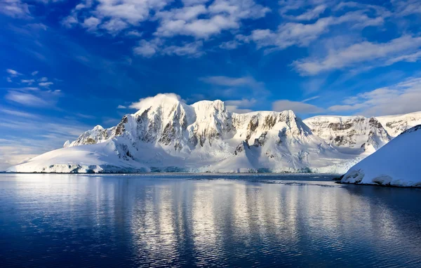 南極の青い空を背景の美しい雪をかぶった山々 ストック写真
