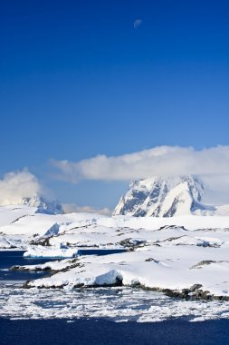 Beautiful snow-capped mountains against the blue sky in Antarctica clipart