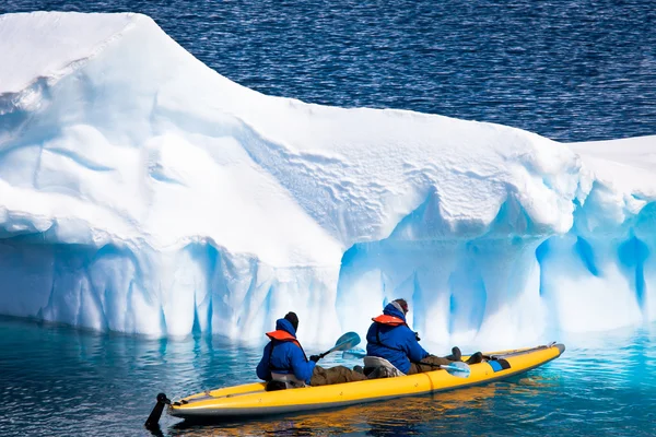 两个男人在一艘独木舟在南极冰山间 — 图库照片