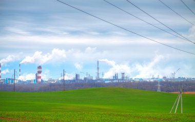 Factory on manufacture of nitric fertilizers with the elevating crane, represented against the blue sky clipart