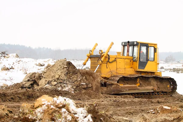 En gul bulldozer arbetar på vintern — Stockfoto