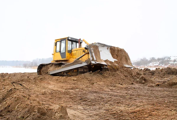 Un bulldozer giallo che lavora in inverno — Foto Stock