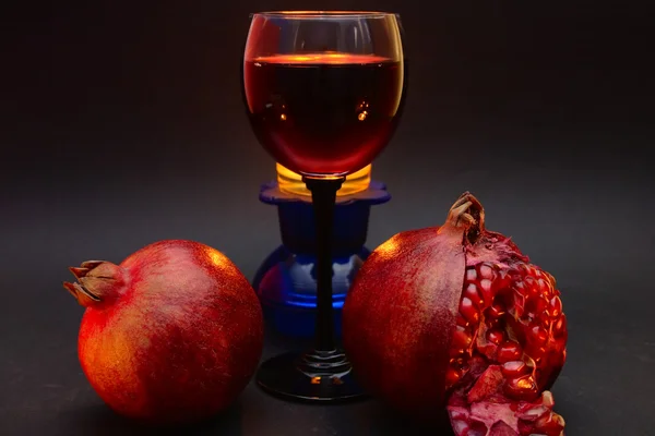 kırmızı şarap bir bardak şarap ve iki adet nar