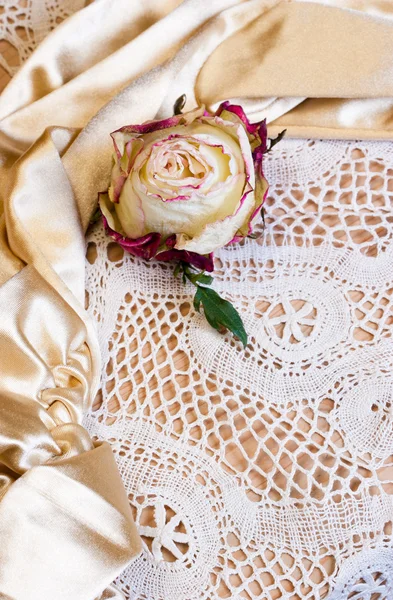 Old rose on an ancient manual lace and gloves. — Stock Photo, Image