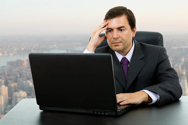与工作的年轻商业男子是在办事处的笔记本电脑 — 图库照片