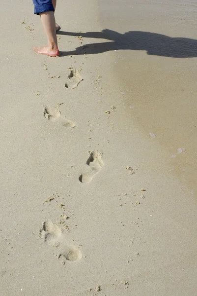 ぬれた砂で歩く女性の足 — ストック写真