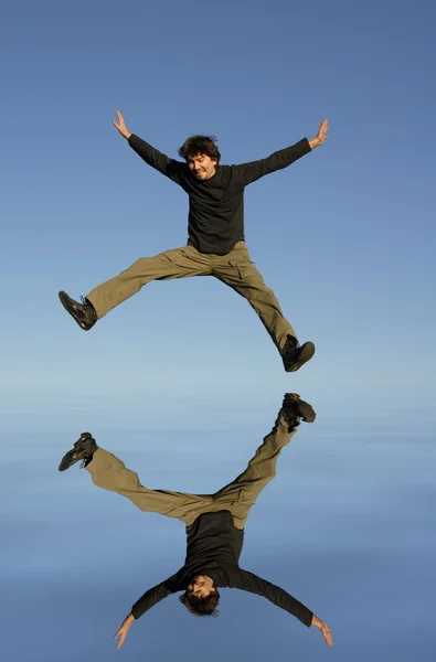 若い男がジャンプ 水デジタル働いた反射 — ストック写真