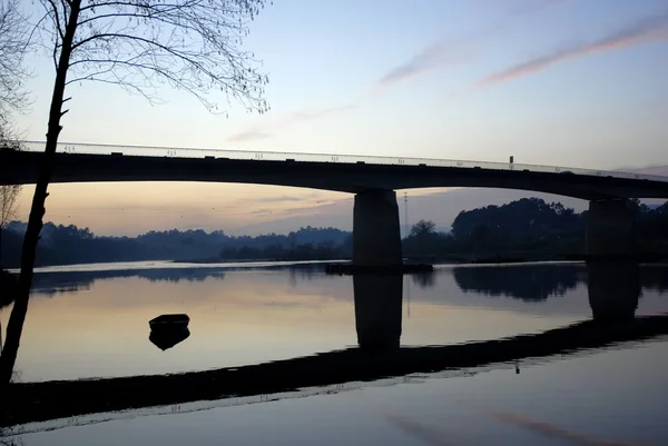 Nehirde Gün Batımı Köprü Altında Bir Tekne — Stok fotoğraf