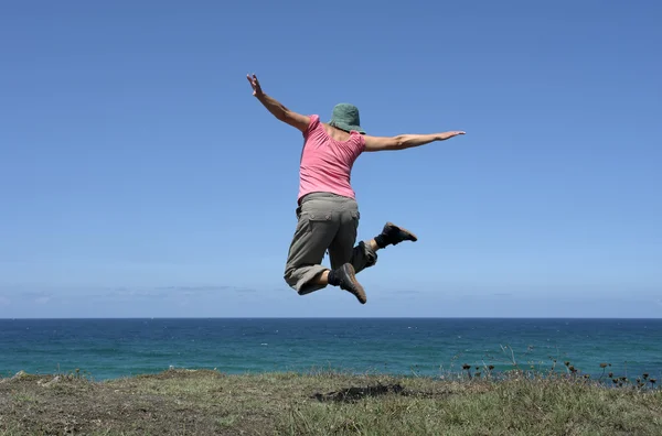 Glückliche Frau Mit Einem Großen Sprung Der Küste — Stockfoto