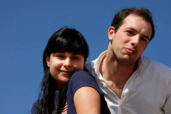 バック グラウンドとして空を持つ若いカップルの肖像画 — ストック写真