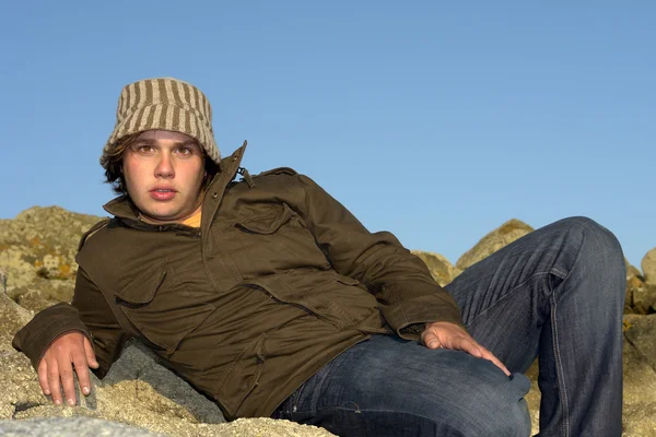Jonge Man Het Rotsachtige Strand Met Een Hoed — Stockfoto