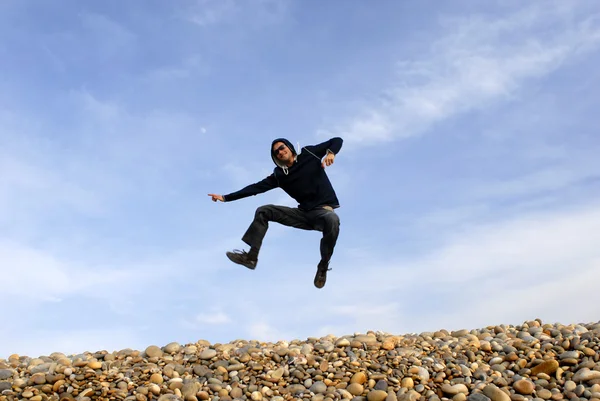 Jonge Man Springt Strand Met Hemel Als Achtergrond — Stockfoto