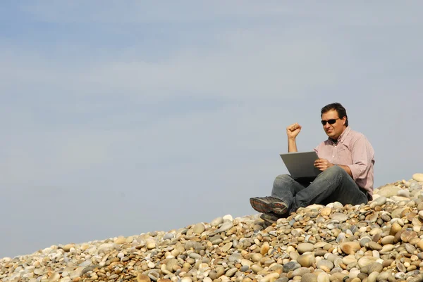 浜のラップトップを持つカジュアルな若者 — ストック写真