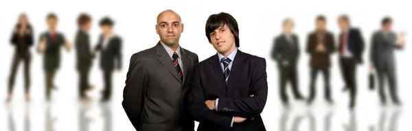 Zwei junge Geschäftsleute mit einigen im Rücken — Stockfoto