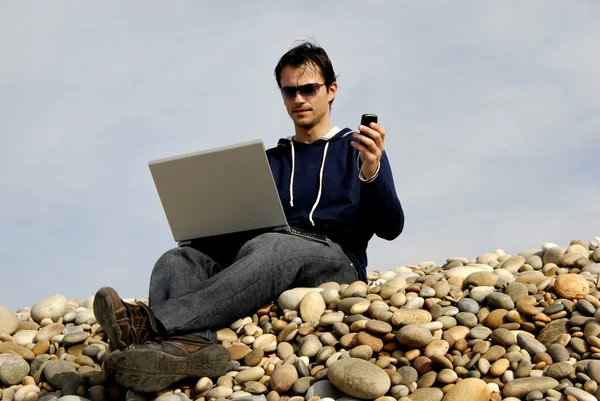 ノート パソコンとビーチで若い男 — ストック写真