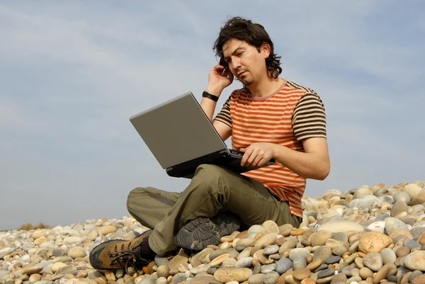 笔记本电脑在海滩上休闲的年轻人 — 图库照片