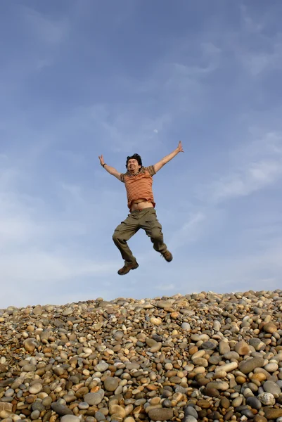 Ung Man Hoppar Stranden Med Himlen Som Bakgrund — Stockfoto