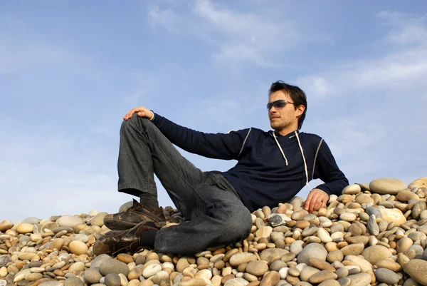 年轻休闲男子在海滩石头 — 图库照片