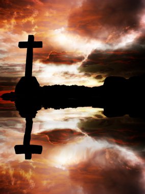 Cross silhouette at sunset with water reflection clipart