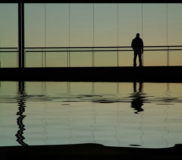 Homem no edifício, com reflexão de água — Fotografia de Stock