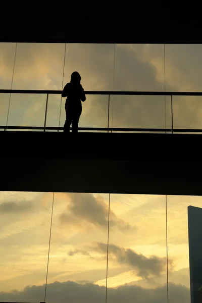Γυναίκα Στο Σύγχρονο Κτίριο Στο Ηλιοβασίλεμα — Φωτογραφία Αρχείου
