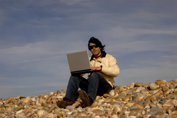 笔记本电脑在海滩上休闲的年轻人 — 图库照片