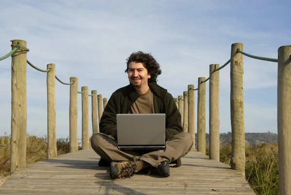 在海滩上与计算机工作的年轻人 — 图库照片