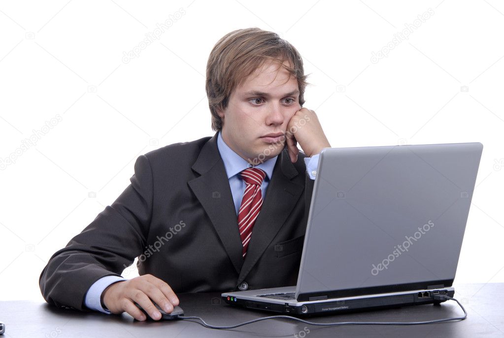 Young bored business man working with is laptop