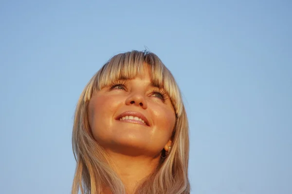 Beautiful girl on a background blue sky — Stock Photo, Image