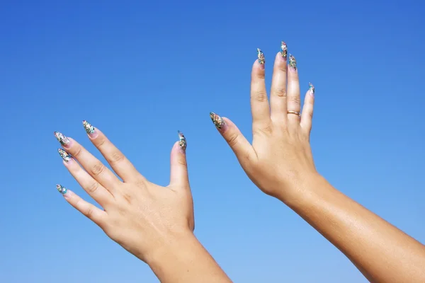 Красивая женщина руки на фоне голубого неба — стоковое фото