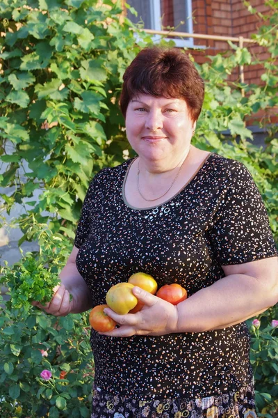 Donna con pomodori in mano — Foto Stock