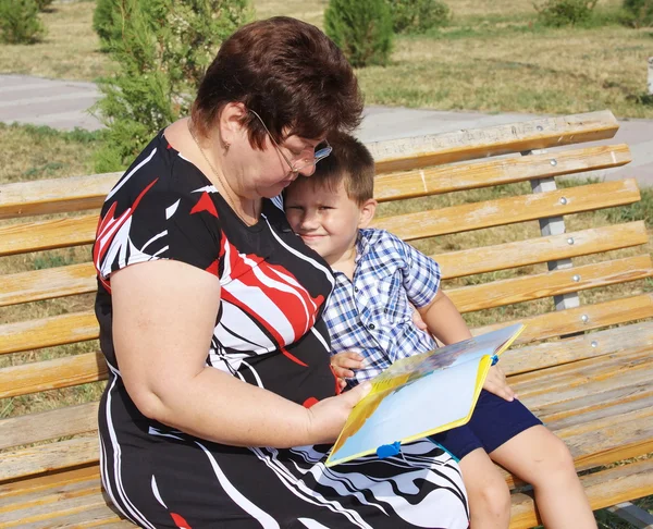 Een grootmoeder leest een boek naar het kleinkind — Stockfoto