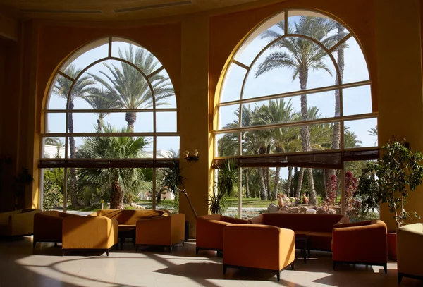 Hotellobby Mit Großem Fenster Und Palme Draußen lizenzfreie Stockfotos