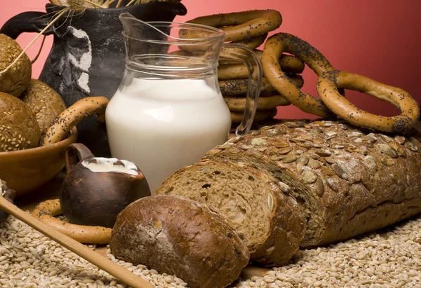 Крупный план с зерновым хлебом, зерном, молоком и бубликами . — стоковое фото