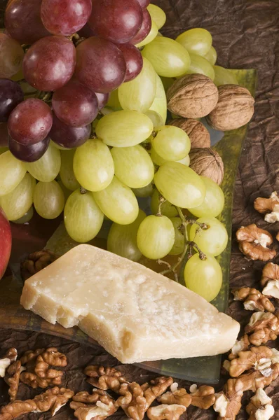 Hard cheese with grape and nuts. — Stock Photo, Image