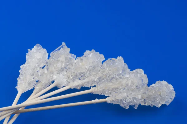 Doce açúcar de caramelo branco sobre azul — Fotografia de Stock