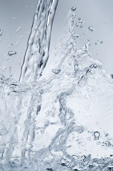 Water stream with splash on blue — Stock Photo, Image