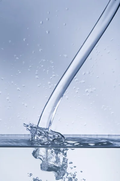 Vattenströmmen med stänk på blå — Stockfoto